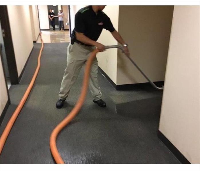servpro employee cleaning up water damage