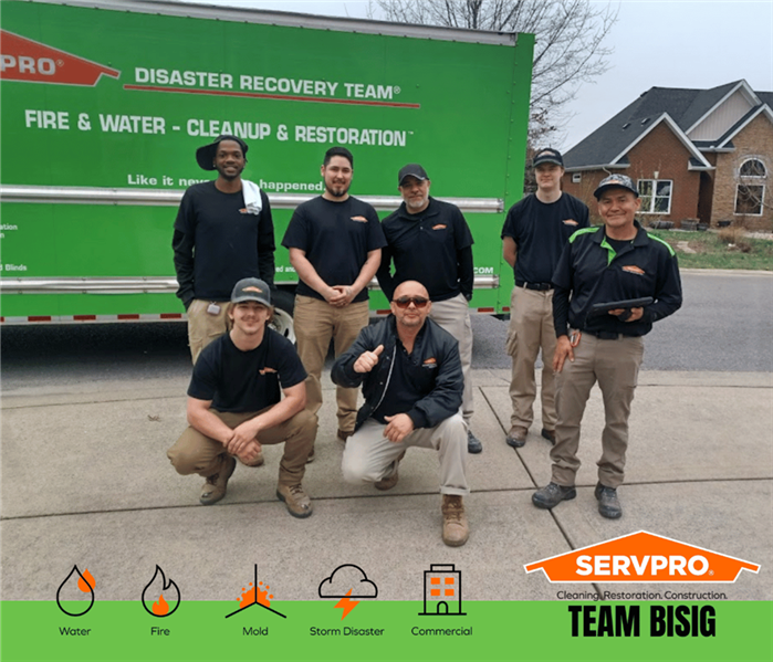 SERVPRO Water Damage Restoration technicians posing in front of a SERVPRO truck after a successful restoration project.